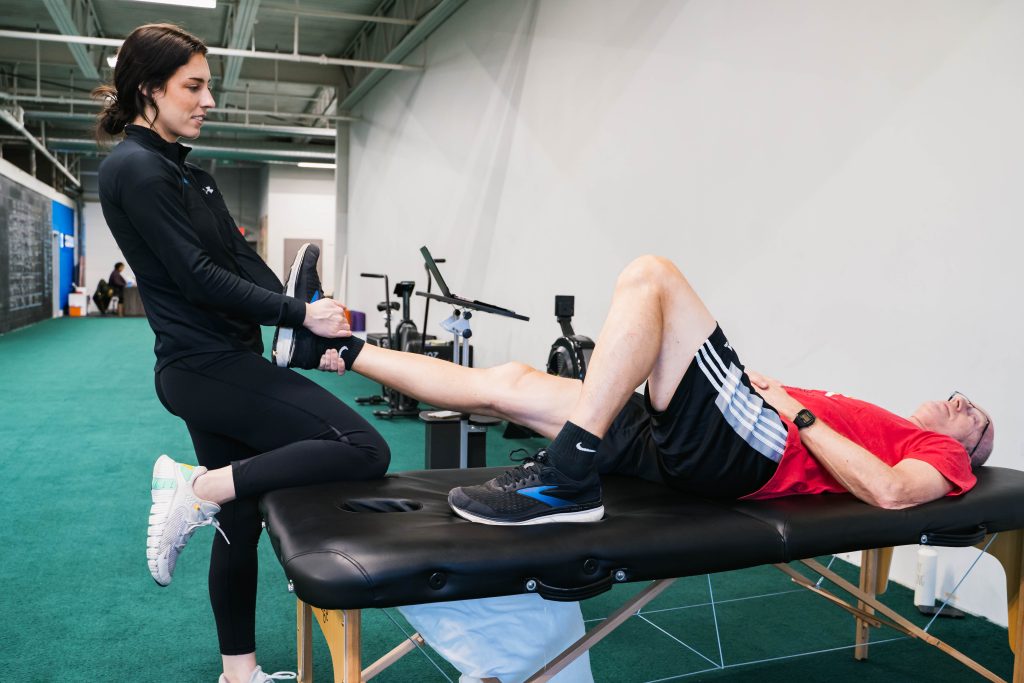 Physical therapist performing a low-impact knee stretch on a patient at Next Level Physical Therapy in Southampton, PA