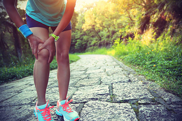 Woman outside holding her knee from pain after exercise