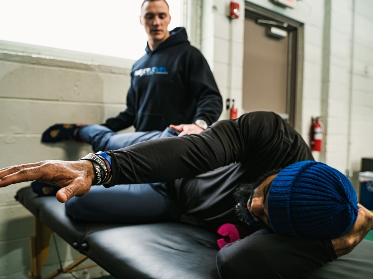 ATHLETE PERFORMING REHAB MOVEMENT ASSESSMENT WITH A PHYSICAL THERAPIST