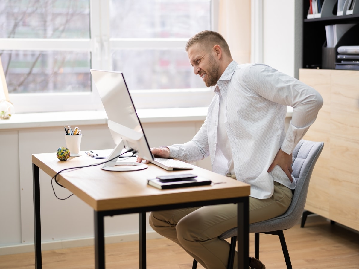 ACTIVE ADULT WORKING AT DESK OR COMPUTER WITH EMPHASIS ON PROLONGED SITTING POSITION