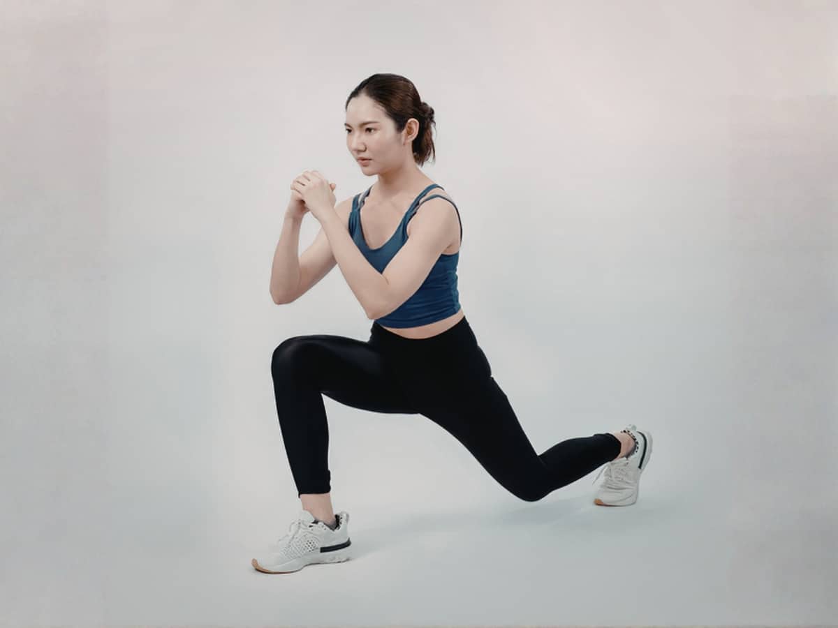 ATHLETE PERFORMING DYNAMIC WARM-UP SEQUENCE OF LUNGES