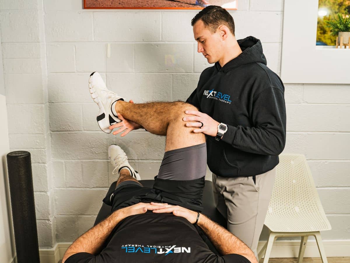 PHYSICAL THERAPIST ASSESSING HIP MOBILITY