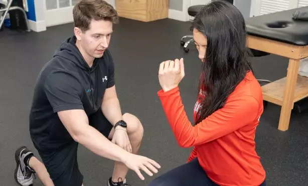 Physical therapist helping a patient with her lunging form at Next Level Physical Therapy in Hamilton, NJ