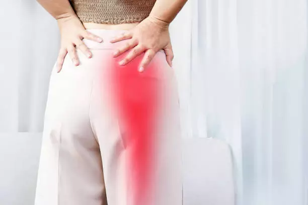 Woman holding her back from sciatica pain
